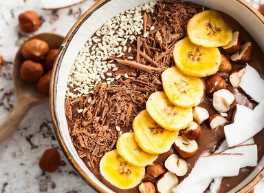 Proteínová kaša s čokoládovou príchuťou zdobená kokosom, semienkami, strúhanou čokoládou, lieskovými orechmi a kolieskami banánu.