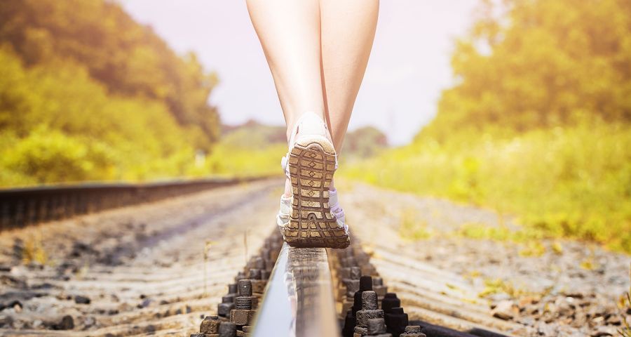Žena kráčí po kolejích. Změna životního stylu je během na dlouhou trať.