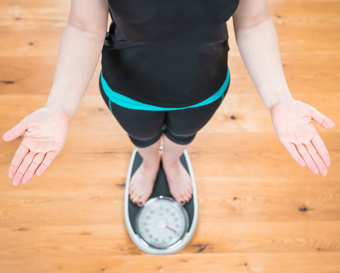 Žena na váze – při ketóze tělo čerpá energii z tukových zásob.